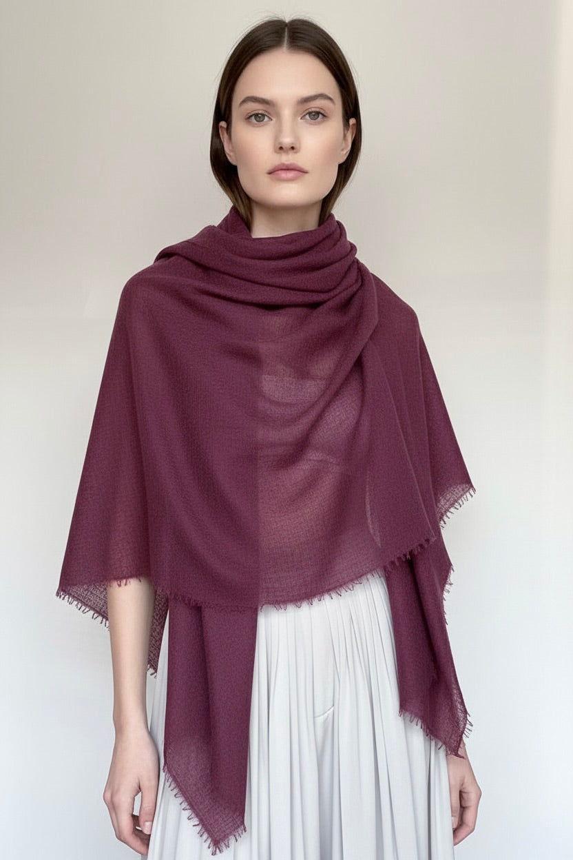 Woman wearing a dark purple scarf on a white background