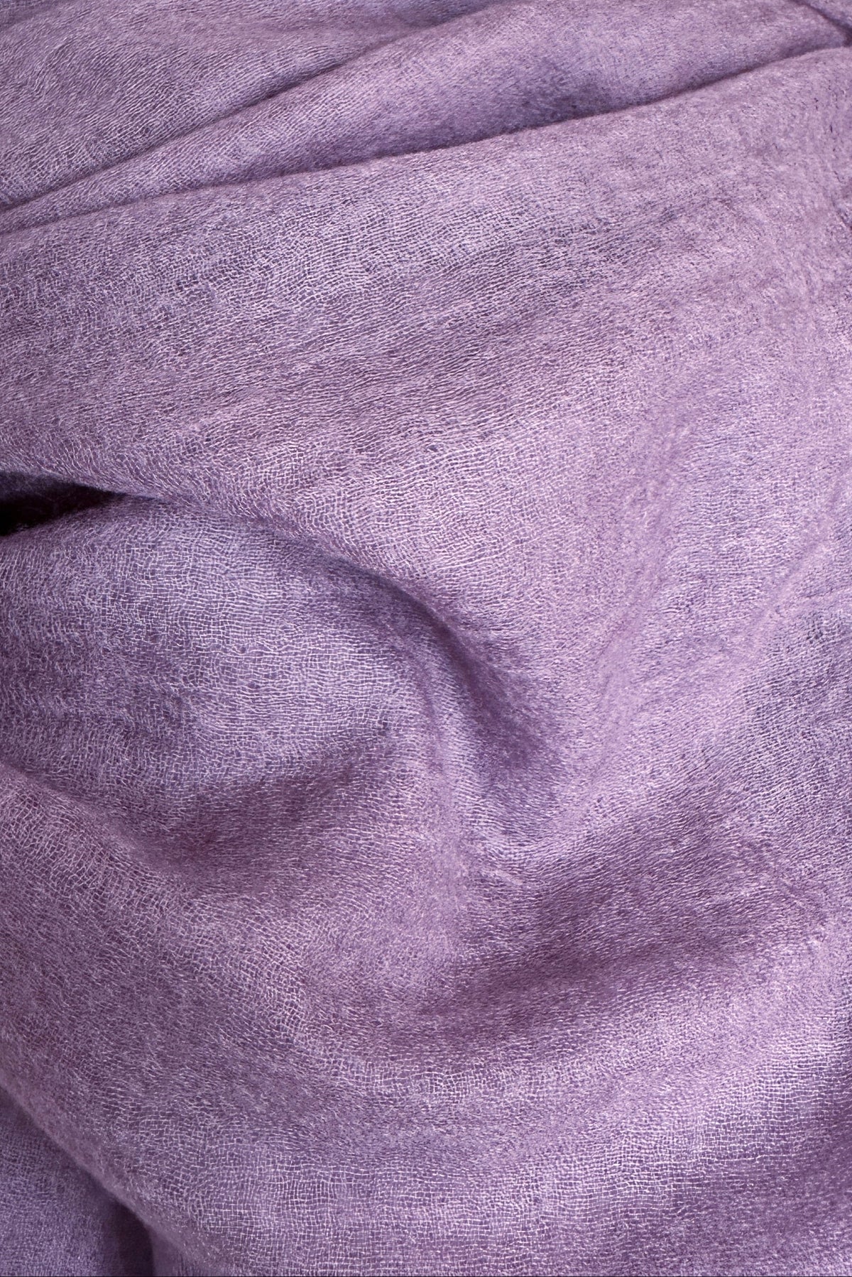 A close-up of a draped lavender-purple fabric, likely a scarf or wrap,