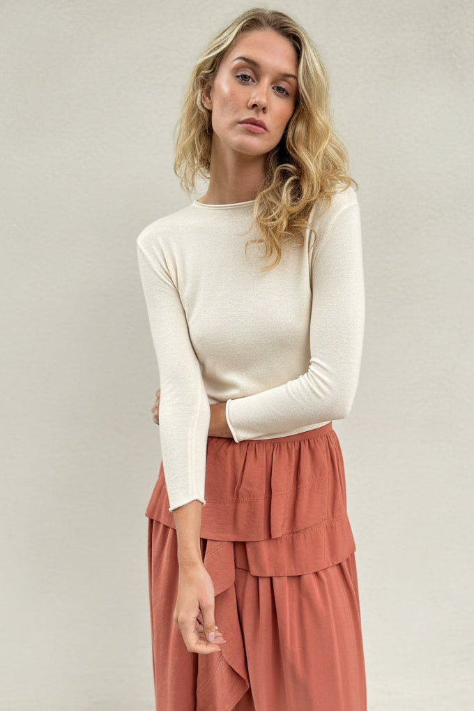 model wearing an ivory cashmere silk top or sweater and pink skirt 