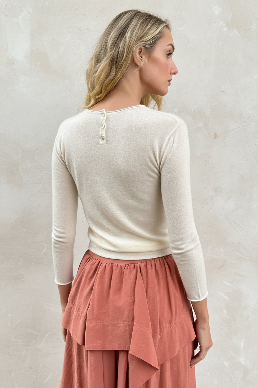 model wearing an ivory cashmere silk top or sweater and pink skirt back view