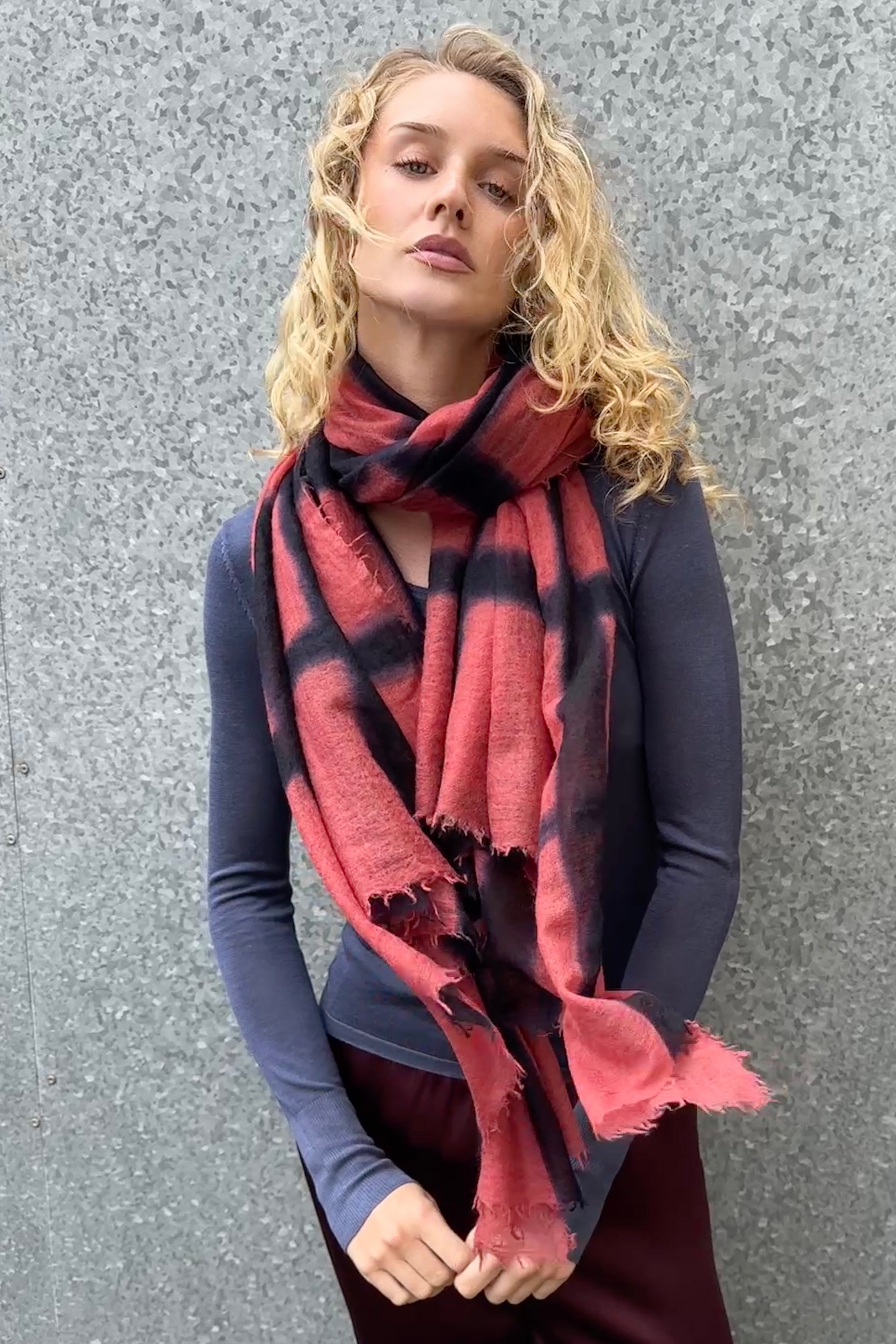 Woman wearing a red and black checkered scarf against a gray background