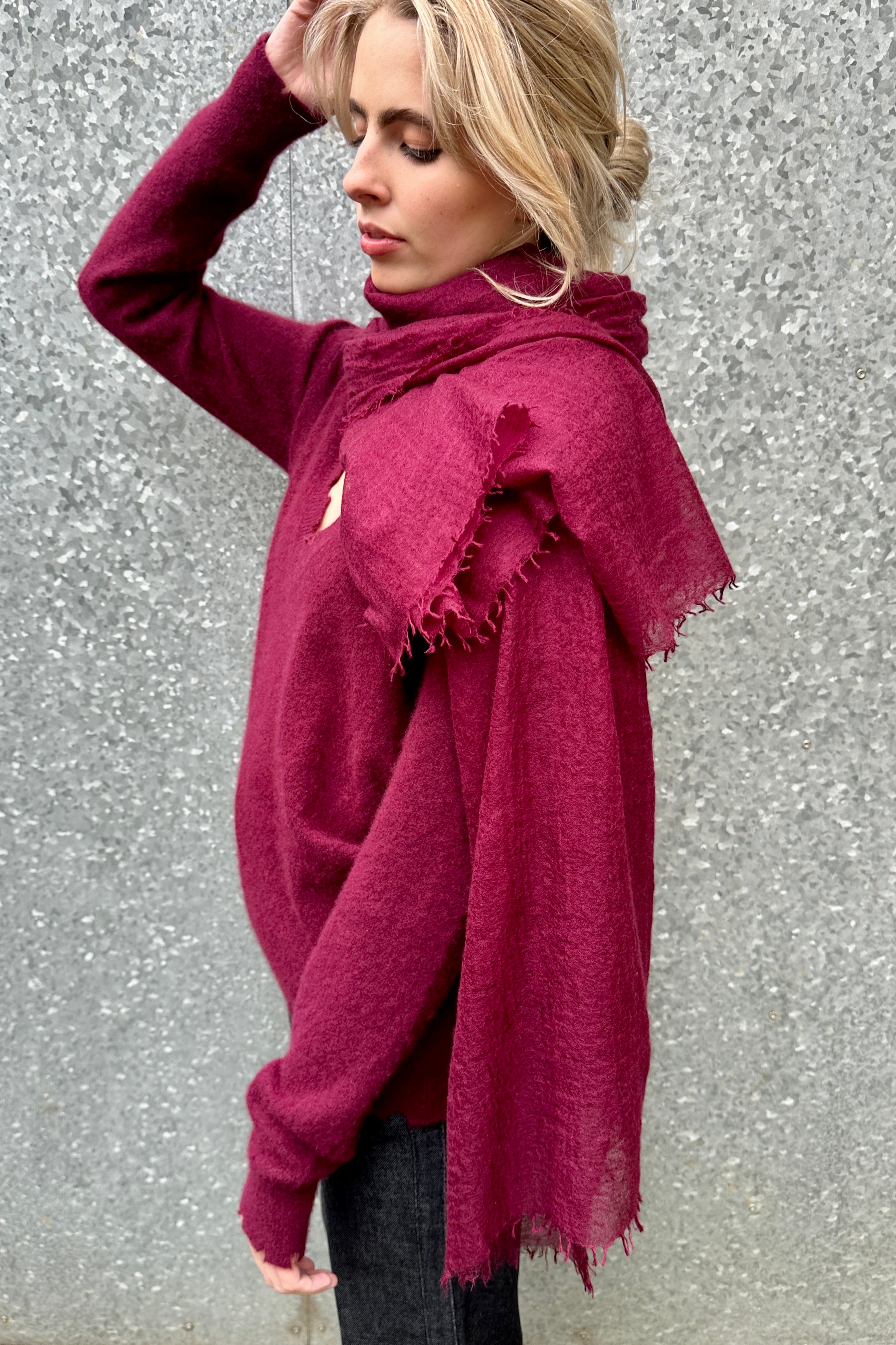 Woman wearing a burgundy cashmere marmee scarf against a textured gray background