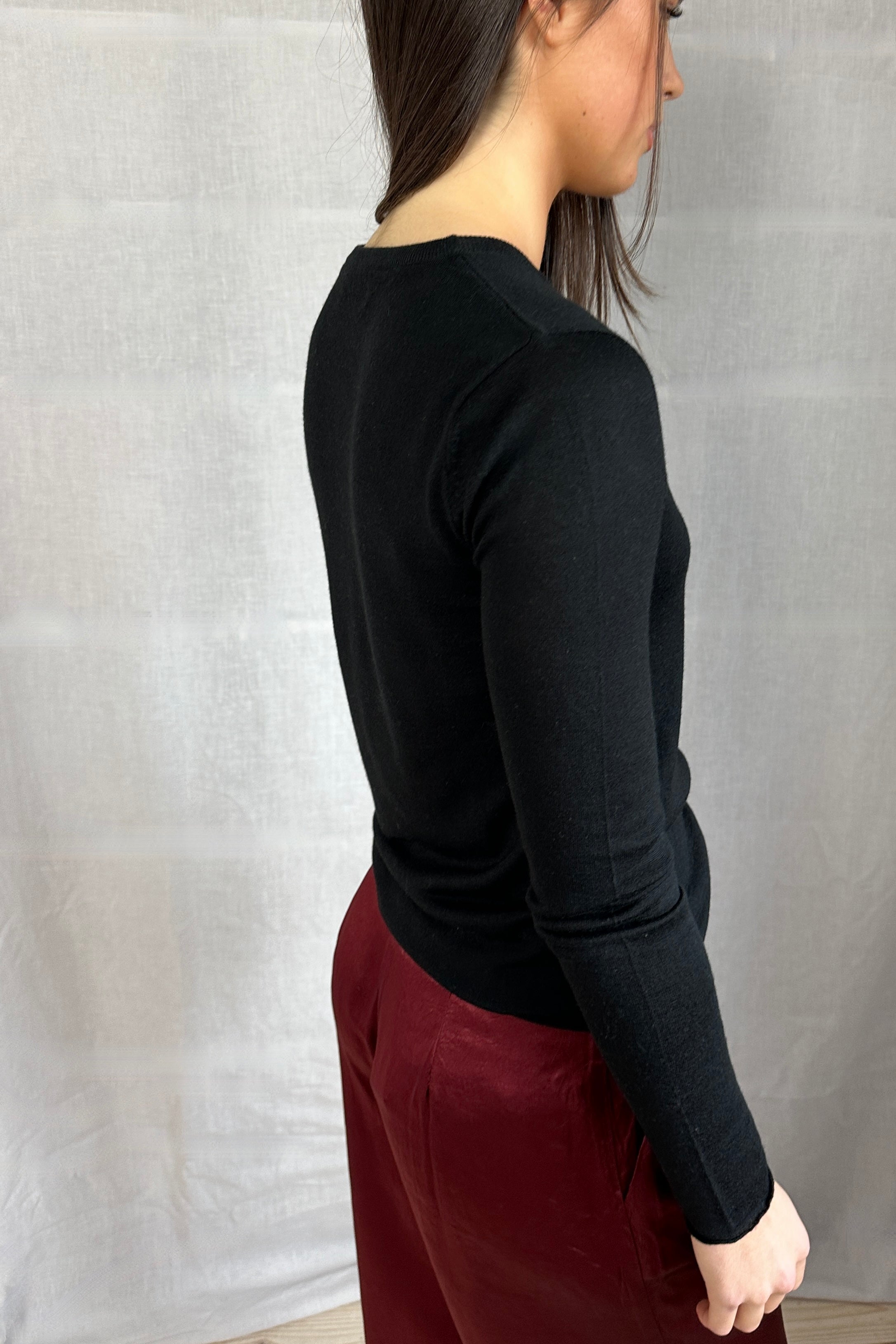 Model wearing a Lassa Square neck black long-sleeve top and maroon pants against a gray background back view