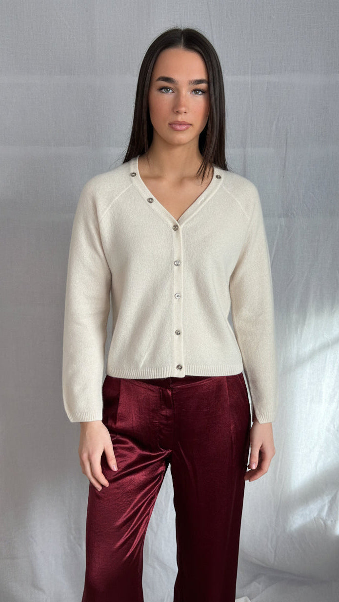 model wearing a cream cashmere cardigan against a plain background ,zelia feather 2