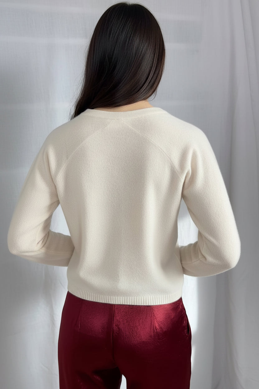 model wearing a cream cashmere cardigan against a plain background ,zelia feather back view