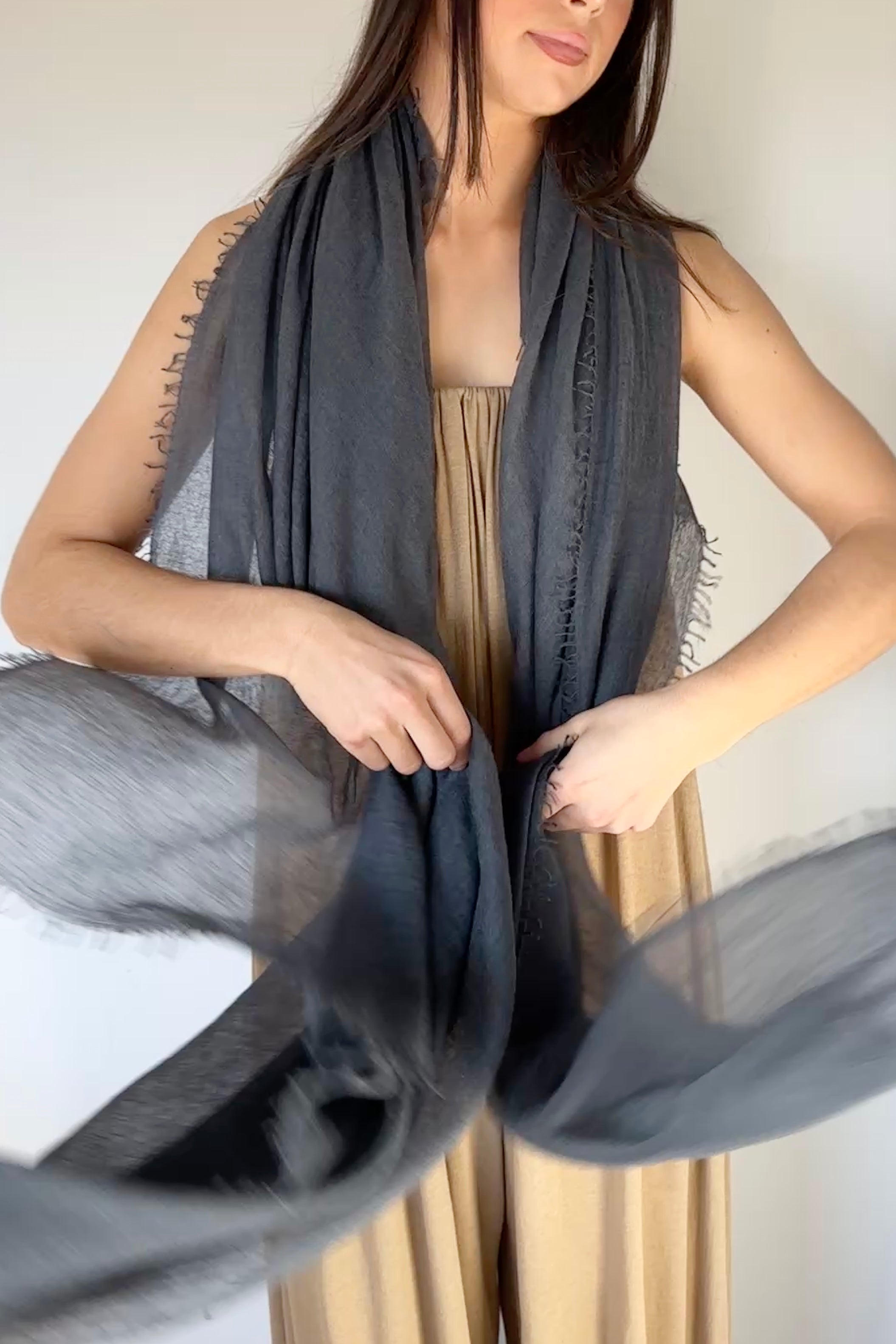 model wearing a dark petrol marmee cashmere  gray scarf with a neutral background
