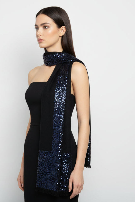 Woman wearing a black dress with a sequined scarf on a white background