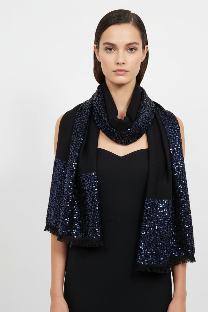Woman wearing a black dress with a blue sequin scarf on a white background