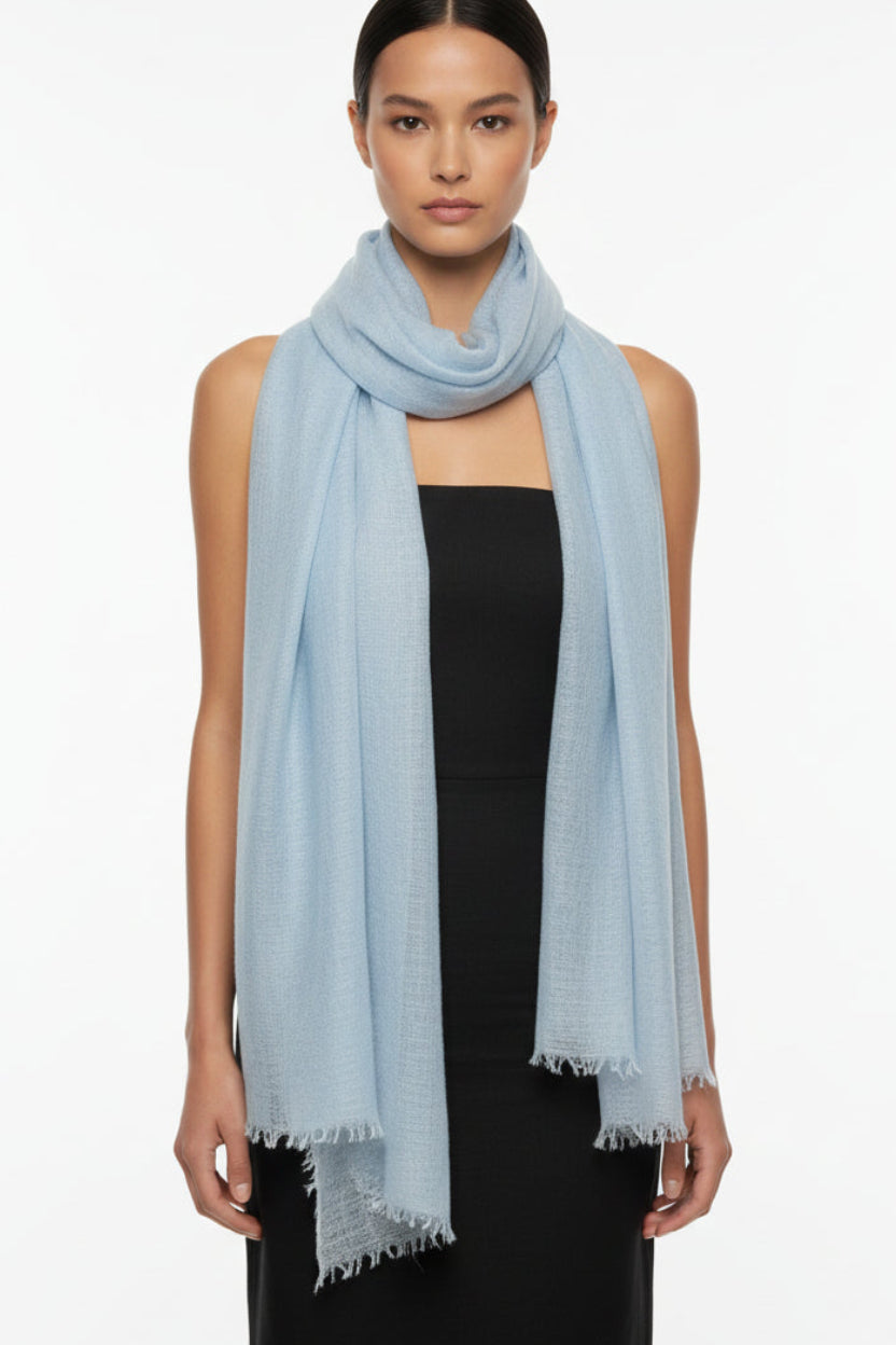 model in pale blue cashmere scarf  against a white background