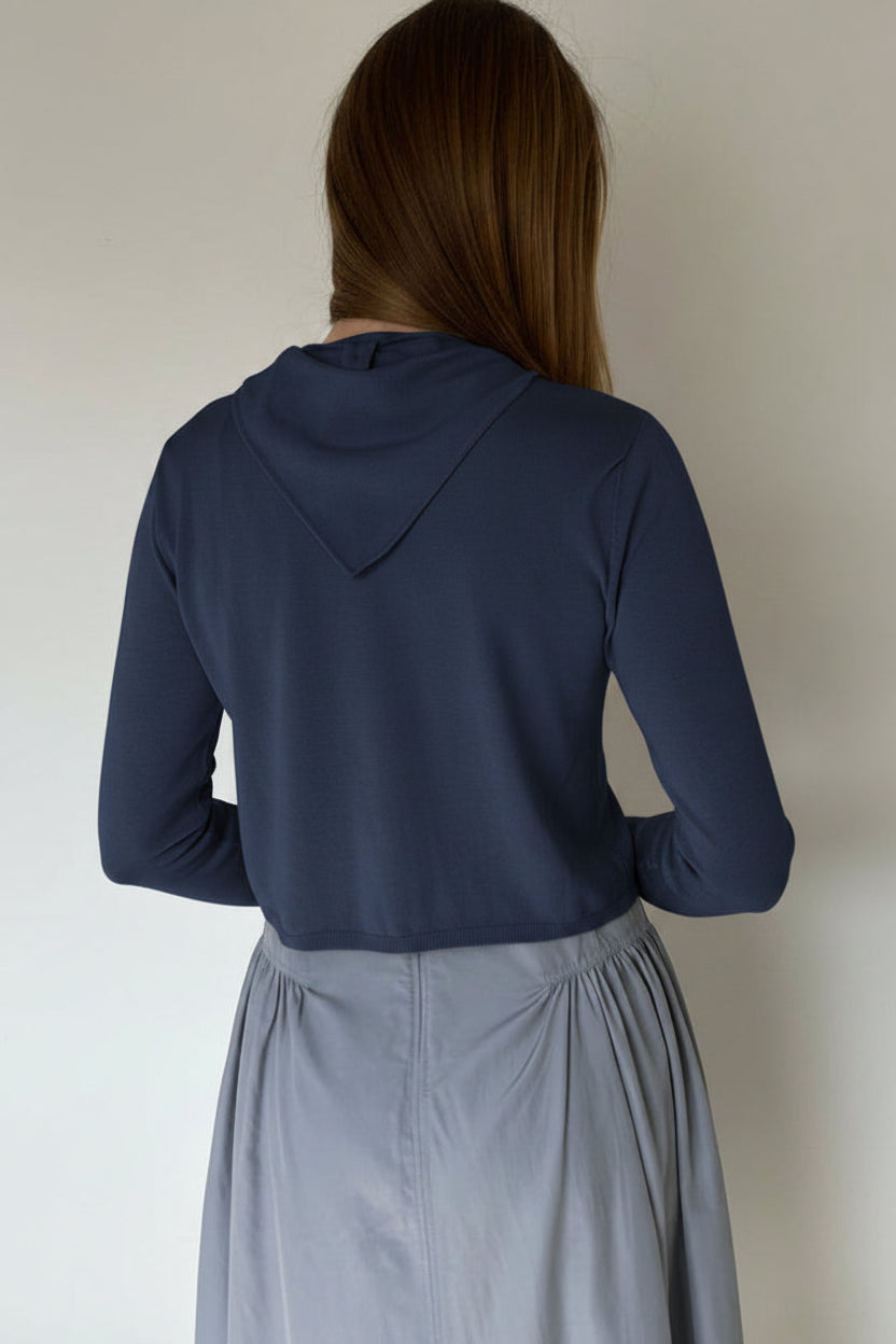 model in a navy cardigan back view with a triangle scarf, white background