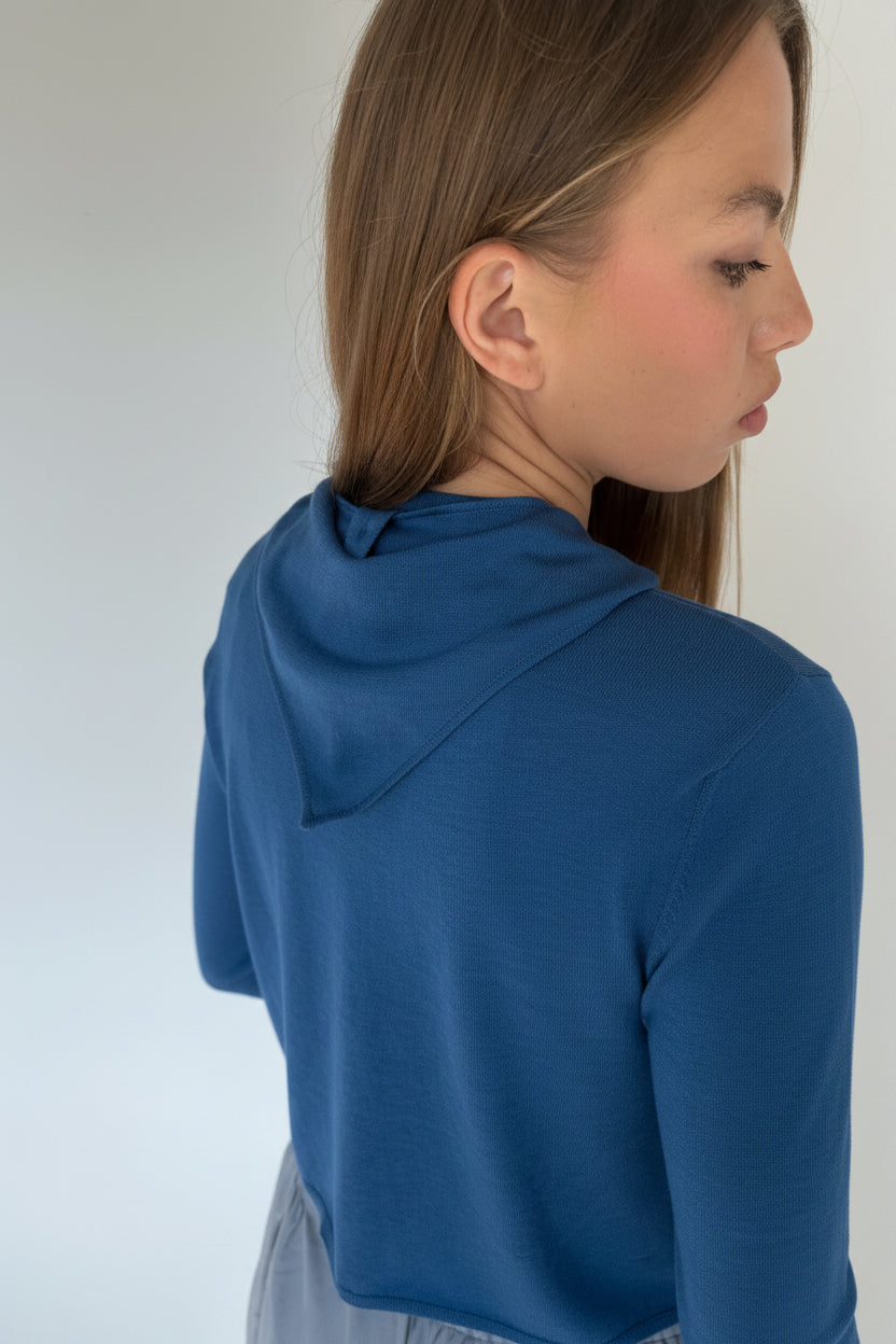 Person wearing a navy cardi with triangle scarf against a white background