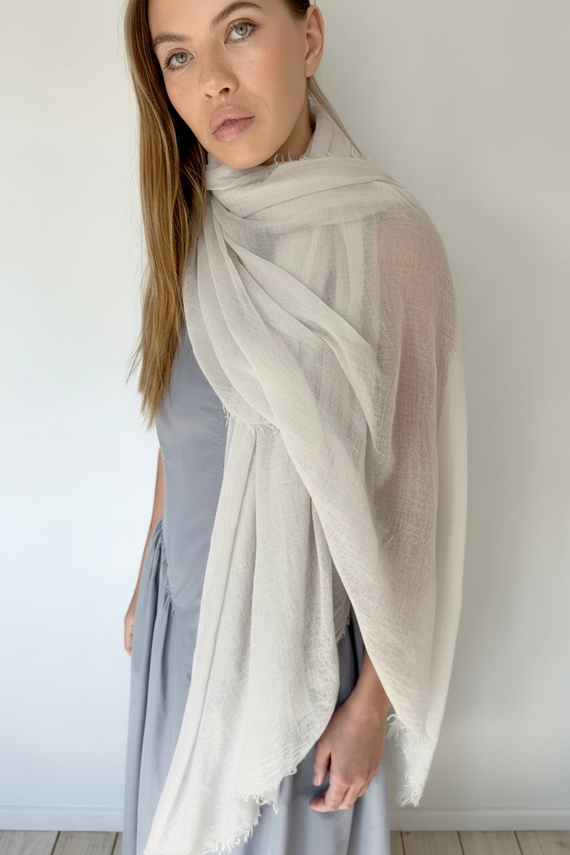 Woman wearing a light gray scarf against a white background